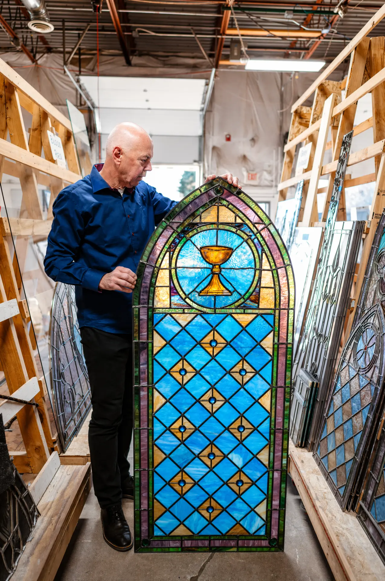 Martin Faith, Founder and CEO, at work on a stained glass panel