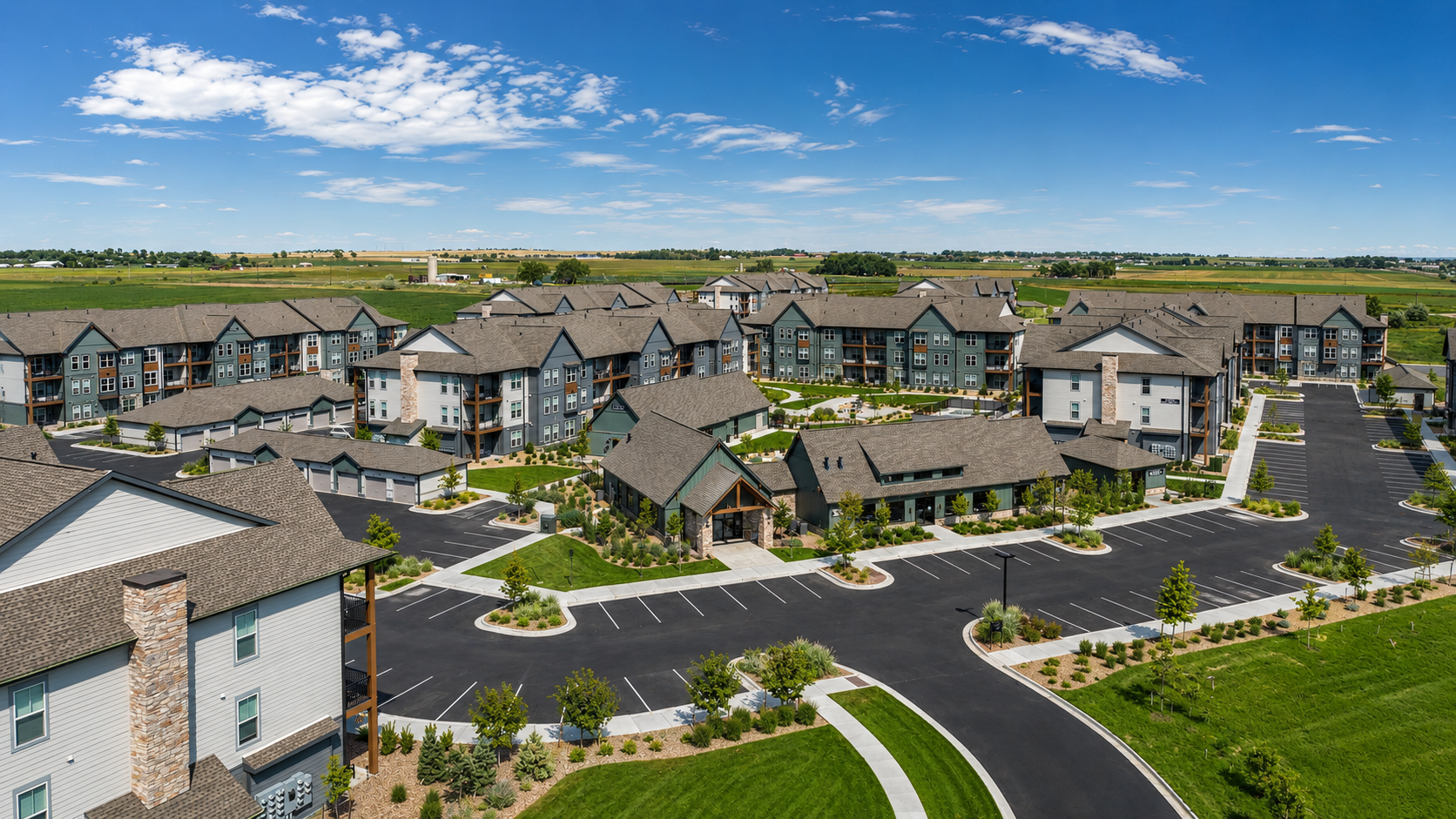 Aerial view of a large Colorado multifamily community with newly finished siding, trim and rooflines under a clear blue sky